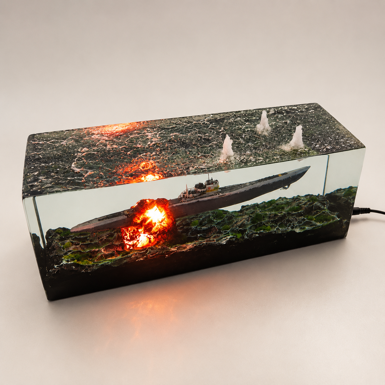 Modellino sottomarino militare incapsulato in resina trasparente con effetti d'acqua, siluri e fumo, ideale come pezzo da collezione o lampada decorativa a tema navale.