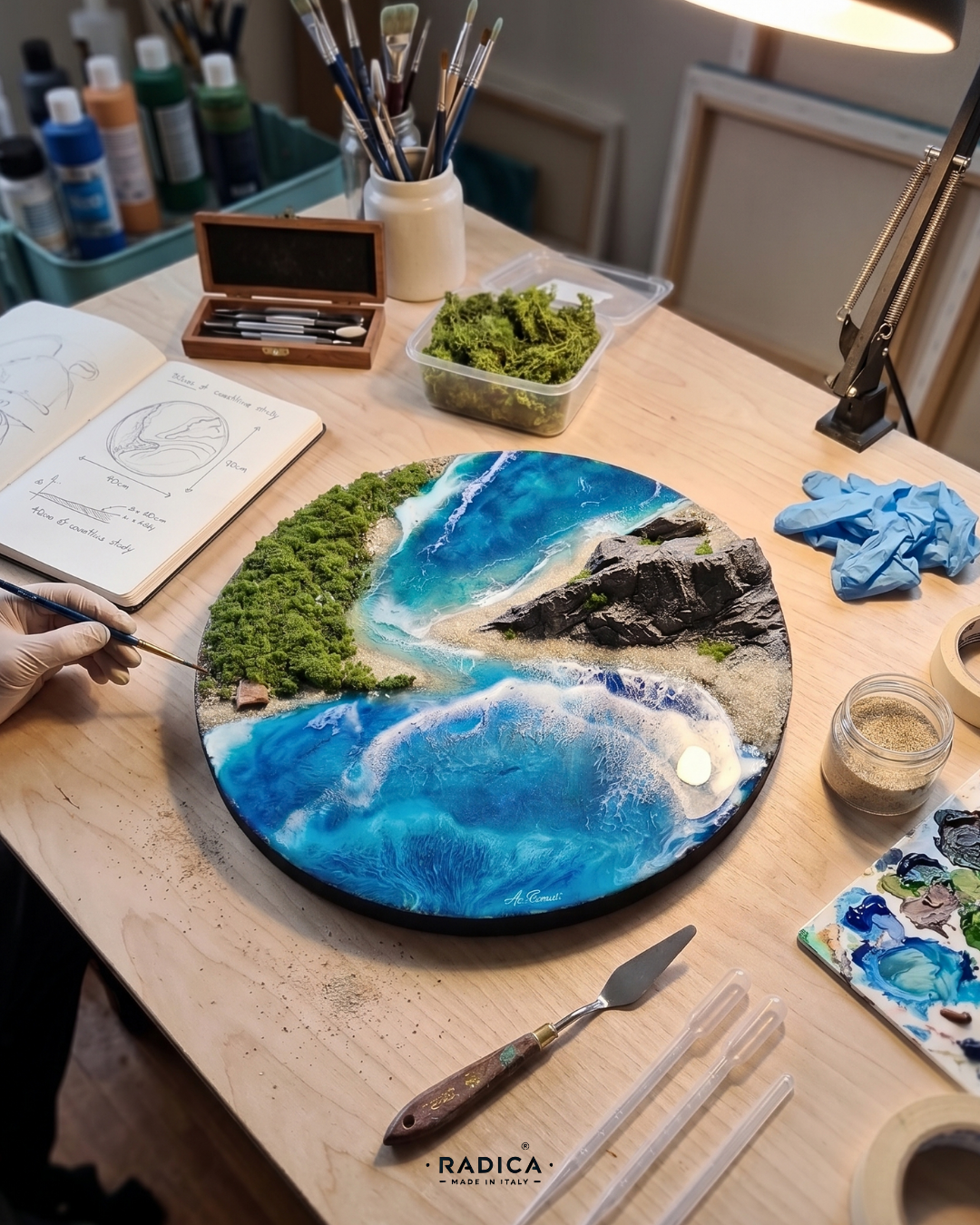 Vista angolata del diorama costiero in resina, che evidenzia lo spessore tridimensionale dei rilievi e la stratificazione dell'acqua.